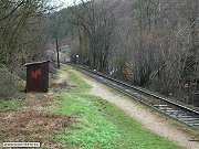 Celkový pohled na původní železniční zastávku Petrov-Chlomek ze směru od Davle. Snímek z 16. března 2008 zachycuje jak sypané nástupiště, tak dřevěnou čekárnu.