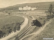 Stará pohlednice z roku 1925 zachycuje hlavní budovu prosečnické léčebny. Okolo jejího rozsáhlého areálu, který tvořily lesy, parky, zahrady a sady právě projíždí parní osobní vlak z Prahy do Čerčan.