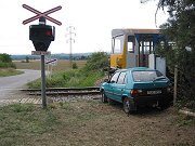 Poškozený automobil Škoda Favorit, který byl po střetu s lokomotivou 714.013 odhozen z prostoru přejezdu. Nehoda se stala 8. srpna 2003 na přejezdu u zastávky Nová Ves pod Pleší.